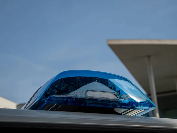 Blue light of a police car siren on a city street. Topics: crime, ambulance and assistance.