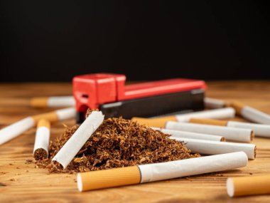 Ahşap bir arka planda sigara ve tütün. Sigara ciğerlere zarar verir ve öldürür. Yakın plan..