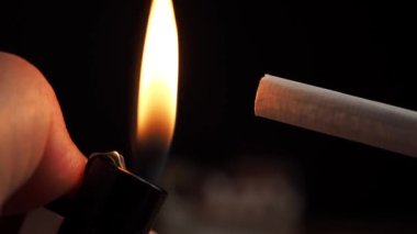 Çakmakla sigara yakıyor. Sigara ciğerlere zarar verir ve öldürür. Yüksek kalite 4k görüntü