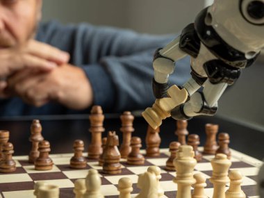 Bir adam bir robotla satranç oynuyor. İnsan robota karşı konsepti.
