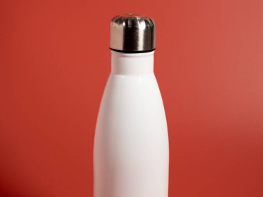 Pembe arka planda beyaz termal şişe. Termos şişesi. Yakın plan..