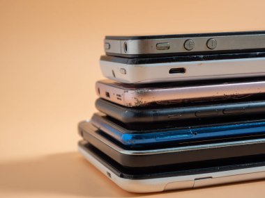 Eski bozuk akıllı telefonlar. Turuncu arka planda akıllı telefonlar. Yakın plan..