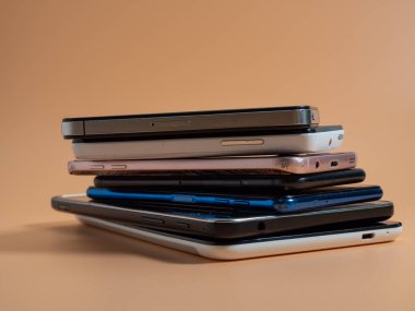 Eski bozuk akıllı telefonlar. Turuncu arka planda akıllı telefonlar. Yakın plan..