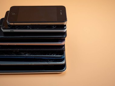Eski bozuk akıllı telefonlar. Turuncu arka planda akıllı telefonlar. Yakın plan..