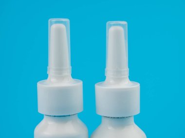 Tıp konsepti. Mavi arka planda burun spreyi. Yakın plan..