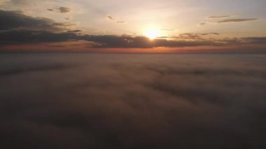 Bulutların üzerinde uçuyor. Bulutların üzerinde güzel bir gün doğumu ya da gün batımı. Turuncu gökyüzü. Sabah sisi ile güzel bir gün doğumu manzarası. Hava görüntüsü. Renkli gökyüzü arka planı