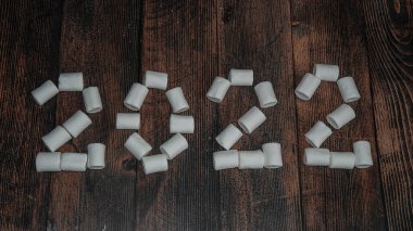 2022 noeli ahşap bir zemin üzerinde yazılı bir yer, bir Noel afişi.