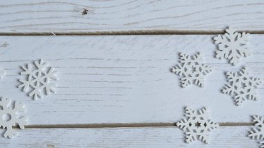 Ekonomik ahşaptan yapılmış beyaz kar taneleriyle süslenmiş beyaz ahşap arka plan, Noel ve tatil kavramı