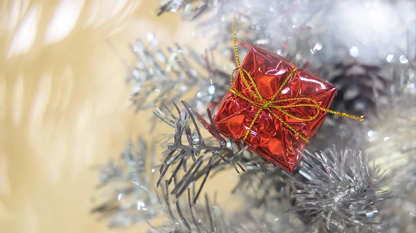 Новогодний подарок на ветку серебряной елки с боке — стоковое фото