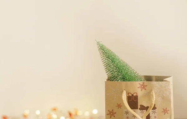 A small artificial Christmas tree in a craft paper gift bag — Stock Photo, Image