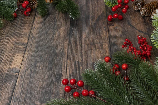 Sfondo di Natale in legno con ramoscelli di abete e bacche rosse — Foto Stock