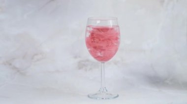 Kalıcı dudak makyajı için kırmızı pigment bir bardak suda yavaşça erir.