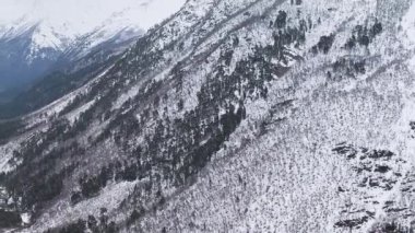 Ağır çekim. Karla kaplı dağ yamaçlarının ve vadinin en üst manzarası..