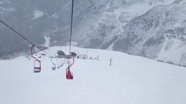 Ağır çekim. Dağ otelinin kayak pistinin ve insanların olduğu teleferiğin üst görüntüsü..