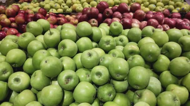 Vista de la cosecha de manzanas de diferentes variedades de rojo y verde en el mostrador en la tienda. — Vídeos de Stock