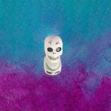 Kafatasından yapılmış cadılar bayramı düzenlemesi mor-mavi arka plana yansıyor. En az korku ve Cadılar Bayramı konsepti. Moda renk arkaplanı.