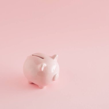 Pembe arka planda pembe bir kumbara. Minimum tasarruf kavramı. Uluslararası tasarruf günü ilhamı.