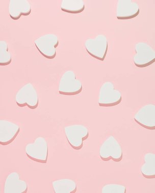 Pembe arka planda beyaz tahta kalplerden yapılmış desen. Minimum düz konsept. Aşk ve Sevgililer Günü ilhamı.