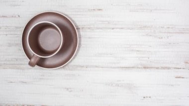 Tahta beyaz bir masada limonlu, zencefilli ve tatlı ballı çay yapma hareketini durdurun. Eller bardağı çerçeveden çıkarsın.