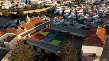 Portekiz, Lagos 'taki renkli bir okulun havadan görünüşü. Sonbahar geldi ve güneş mimariyi altın rengine boyuyor..