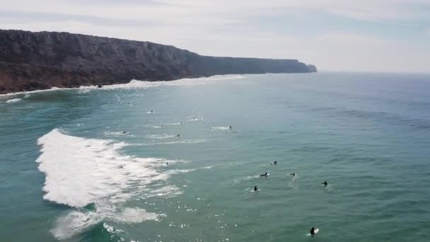 ポルトガル西海岸のサーファーの空中映像 崖に囲まれたサグレスのサーファーがいる小さなビーチを示しています — ストック動画
