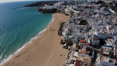 Albufeira sinematik dron hava görüntüsü. Güzel sahil şeridi, sahil ve eski kasaba üzerinde İHA uçuşu. Atlantik okyanusunda güneşli bir hava.  
