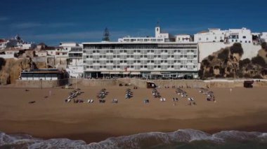 Albufeira sinematik dron hava görüntüsü. Güzel sahil şeridi, sahil ve eski kasaba üzerinde İHA uçuşu. Atlantik okyanusunda güneşli bir hava.  