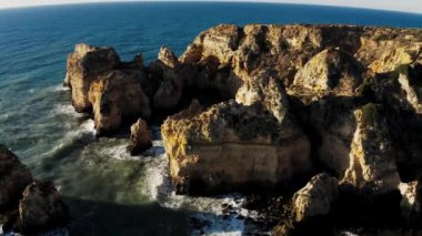 Sahil kayalıkları Portekiz hava manzarası. Ponta Da Piedade üzerinde insansız hava aracı uçuşu Atlantik Okyanusu üzerinde güzel bir gündoğumunda. 