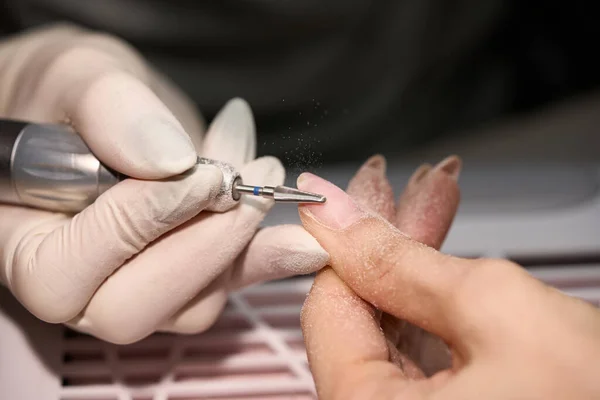 Mulher fazendo manicure para si mesma com a broca de unhas — Fotografia de Stock
