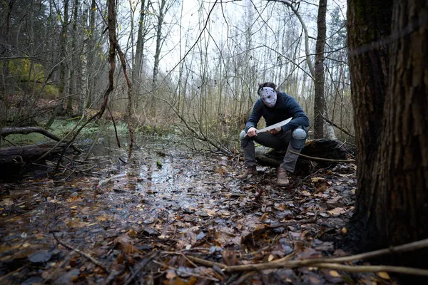 Seri katil Jason Voorhees hokey maskesi ve palayla bataklıkta oturuyor. 13. Cuma Kostümleri. 