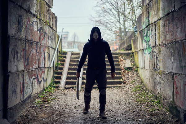 Serial killer Jason Voorhees in hockey mask in the end of the dark tunnel. Friday 13th cosplay costume. 