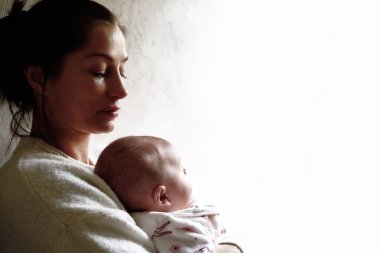 Mutlu anne bebeğini bembeyaz tutuyor.