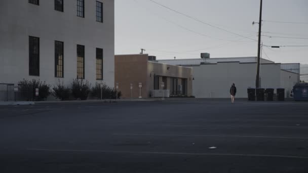 黎明时分在美国犹他州普罗沃空旷停车场散步的遥远女孩 图库视频