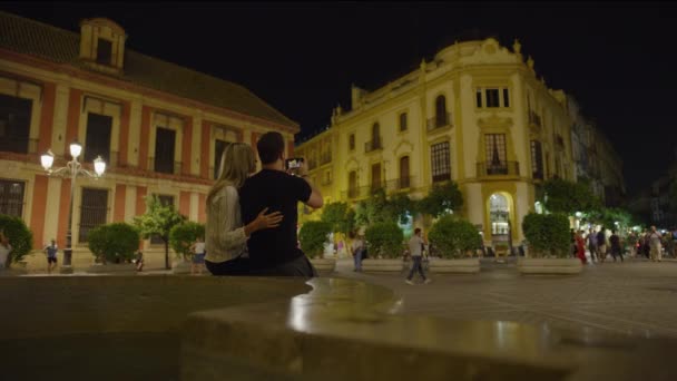 Couple Sitting Bench Photographing Plaza Night Cell Phone Seville Sevilla — Stock Video