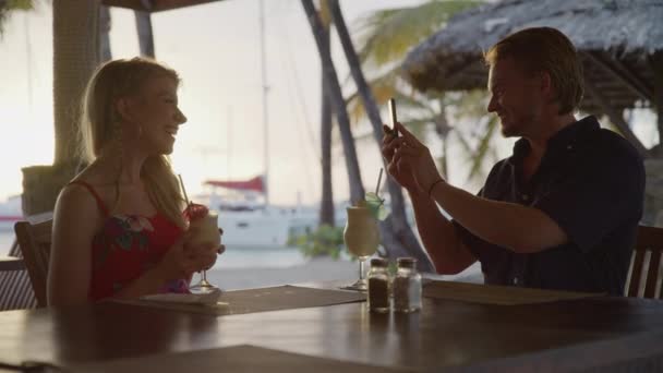 Man Holding Cell Phone Photographing Woman Beach Restaurant Salt Whistle — Stockvideo