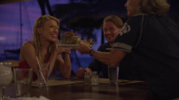 在圣文森特和格林纳丁斯Mayreau的海滩餐馆 Salt Whistle湾为快乐的夫妇提供食物的女服务员 — 图库视频影像