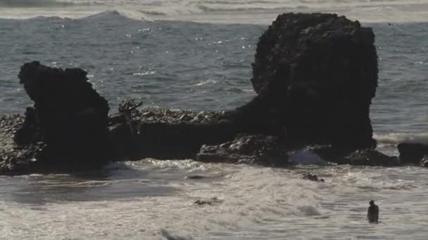 Pessoas Distantes Vagando Ondas Oceânicas Perto Formação Rochosa Tunco Libertad — Vídeo de Stock