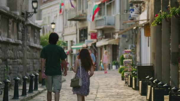 石畳の通りを歩くカップルの広いスローモーションパンニングショット Veliko Tarnovo Burgia — ストック動画