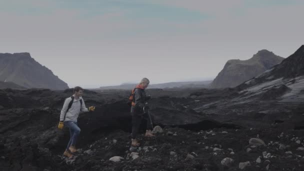 Отслеживающий Снимок Пары Путешествующей Скалистой Местности Вик Исландия — стоковое видео
