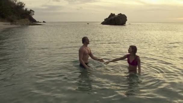Slow Motion Panning Shot Man Hugging Dunking Woman Ocean Anse — стоковое видео