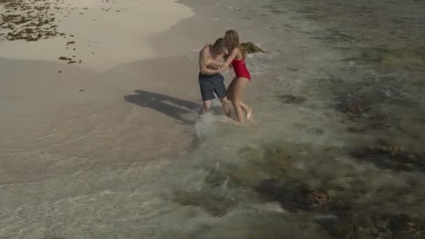 Ευτυχισμένο Ζευγάρι Παίζει Και Πιτσιλίζει Στην Παραλία Του Ωκεανού Petit — Αρχείο Βίντεο