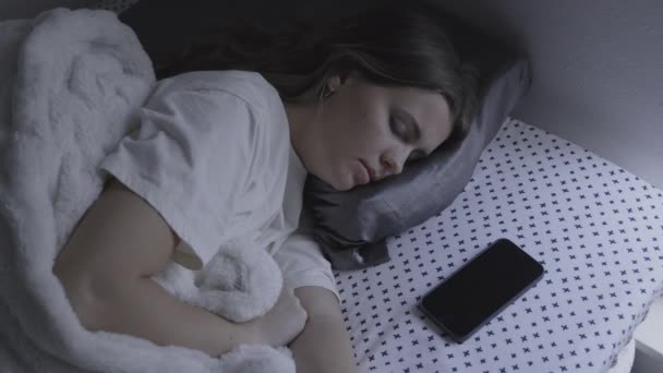 米国ユタ州 プロボ 携帯電話のアラームによって起こされ イライラベッドで寝ている女の子の高い角度のビュー — ストック動画