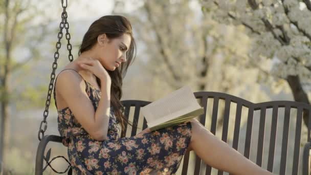Medium Slow Motion Shot Woman Reading Book Bench Swing Cedar — Αρχείο Βίντεο