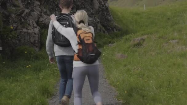 Tracking Shot Man Backpacking Trail Carrying Woman Piggyback Kirkjubaejarklaustur Islandia — Vídeos de Stock