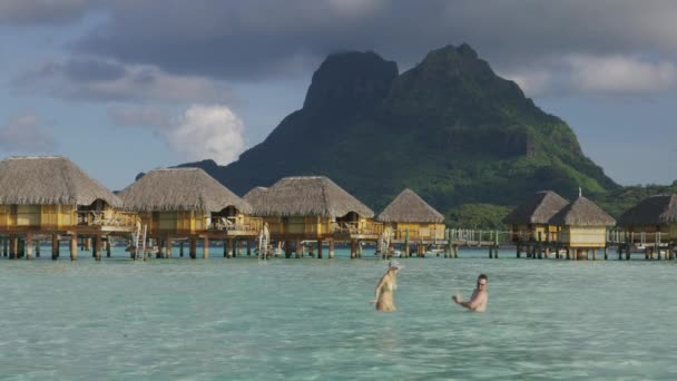Mulher Salpicando Homem Oceano Perto Bungalows Tahiti Bora Bora Polinésia — Vídeo de Stock