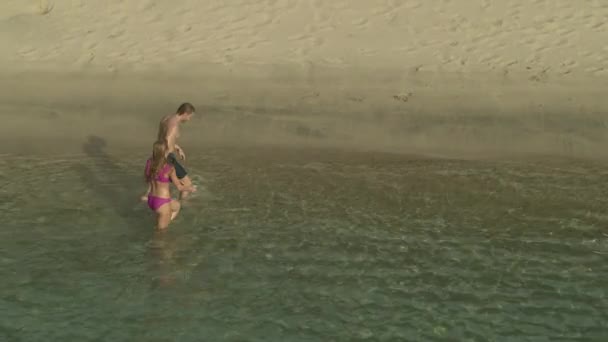 Aerial Panning Shot Couple Walking Ocean Beach Holding Hands Anse — стоковое видео