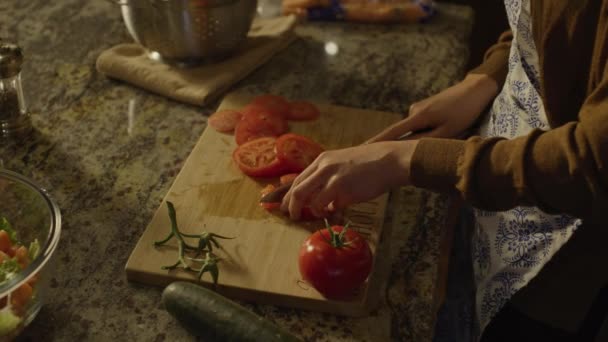 米国ユタ州のキッチン シーダーヒルズでサラダ用のトマトをスライス女性の手の高い角度のクローズアップビュー — ストック動画