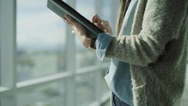 米国ユタ州プレザントグローブのオフィス プレザントグローブの窓の近くのデジタルタブレットに入力するビジネス女性の終わりまで傾ける — ストック動画