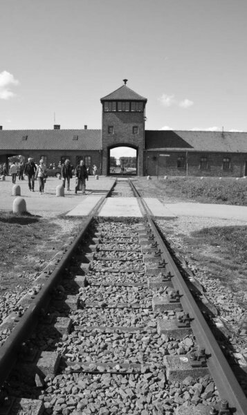 AUSCHWITZ BIRKENAU POLAND - 09 17: Main gate to nazi concentration camp of Auschwitz Birkenau with train rail. Здесь были истреблены 1,5 миллиона человек во время второй мировой войны.
