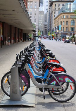 MONTREAL CANADA - 06 14 2022: Bisiklet kiralama servisi Bixi Montreal 'e ait sıralı bisiklet tekerlekleri, kiralık istasyonlarından birinde, Quebec' te bikesim konusunda uzmanlaşmış.